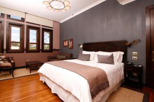 a bedroom with a large bed and a large window at Hotel Boutique Castillo Rojo in Santiago