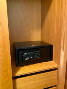 un microondas negro sentado en un estante en un armario en BaiaDaLuz - LuzBaia AS Apartment, en Luz