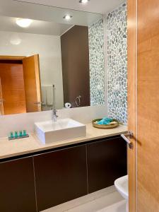 een badkamer met een wastafel en een spiegel bij BaiaDaLuz - LuzBaia AS Apartment in Luz