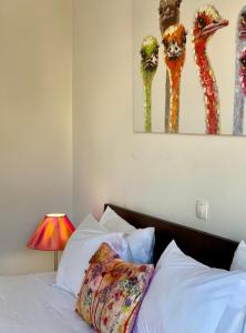 1 dormitorio con 1 cama con una pintura de jirafas en BaiaDaLuz - LuzBaia AS Apartment, en Luz