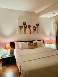 een slaapkamer met een groot wit bed met 2 lampen bij BaiaDaLuz - LuzBaia AS Apartment in Luz