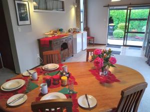 a dining room table with plates and flowers on it at Carters Beach Bed and Breakfast in Westport