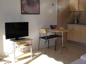 a kitchen with a table with a television and a table with chairs at Acuarium 1 - Zand Properties in Benidorm
