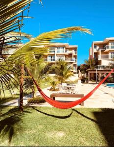 a hammock in front of a resort at Palm Beach Residence in Aquiraz