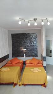 two beds with orange pillows in a bedroom at Sweet studio Playa Del Ingles I in Maspalomas