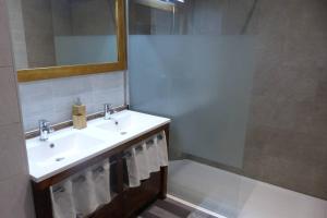ein Bad mit einem Waschbecken und einem Spiegel in der Unterkunft La Gabelle Saint Hilaire in Saint-Pierre-des-Échaubrognes