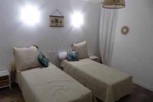 a room with two beds and a chandelier at La Gabelle Saint Hilaire in Saint-Pierre-des-Échaubrognes