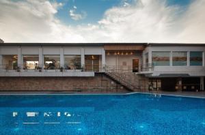 a house with a swimming pool in front of a building at Sinclairs Siliguri in Siliguri