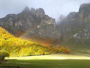 a rainbow in the mountains with a green field at Parador de Fuente Dé in Fuente Dé