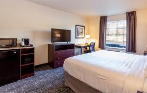 a hotel room with a bed and a television at Cobblestone Inn & Suites - Brookville in Brookville +37 photos