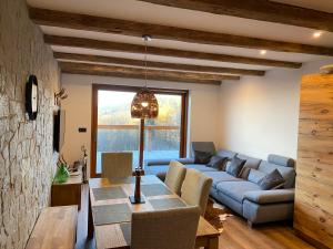 Chalet Apartments Maštal في زيليزنا رودا: غرفة معيشة مع أريكة زرقاء وطاولة