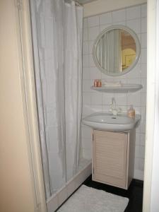 uma casa de banho com um chuveiro, um lavatório e um espelho. em B&B Singel 100 em Amsterdã