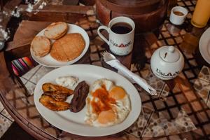 una mesa con un plato de desayuno y una taza de café en Eco Suites Uxlabil Guatemala, en Guatemala