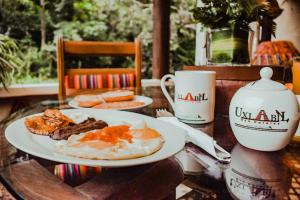 een tafel met twee borden ontbijtproducten en een kopje bij Eco Suites Uxlabil Guatemala in Guatemala