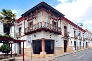 a white building with a balcony on a street at Hotel Monasterio in Sucre