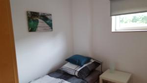 a small bedroom with a bed and a window at Niederdreisbacher Hütte - moderne Doppelzimmer - EINZELBETTEN - in Niederdreisbach