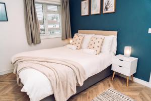 a bedroom with a large bed with a blue wall at Caroline Court - 1 Bedroom Apartment in Colchester