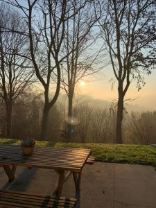 a bench in a park with the sunrise in the background at Chalet Pierco in Malmedy