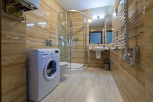 a bathroom with a washing machine and a sink at Mi Casa Holidays Rezydencja Park Rodzinna II in Mielno