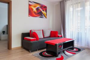 a living room with a couch and a red table at Mi Casa Holidays Rezydencja Park Rodzinna II in Mielno