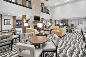 hol z krzesłami i stołami oraz poczekalnia w obiekcie Staybridge Suites Irvine - John Wayne Airport, an IHG Hotel w mieście Irvine