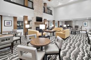 a lobby with chairs and tables and a waiting room at Staybridge Suites Irvine - John Wayne Airport by IHG in Irvine