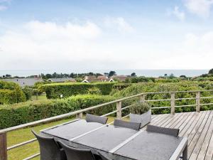 a table and chairs on a deck with a view of the ocean at 6 person holiday home in Slagelse in Slagelse