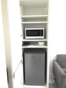 a small kitchen with a microwave and a refrigerator at Apartment style Space ideal for business & contractors in Minworth