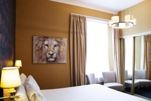 1 dormitorio con 1 cama y una pintura de un tigre en The Montana, en Torquay