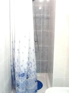 eine Dusche mit einem blauen Duschvorhang im Bad in der Unterkunft Spacious House Aljezur + Balcony in Aljezur