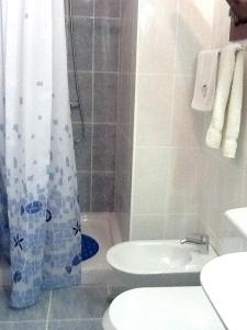 a bathroom with a sink and a toilet and a shower at 3 bedrooms house with city view and enclosed garden at Aljezur 8 km away from the beach in Aljezur