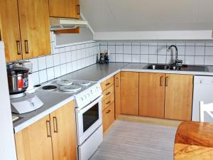a kitchen with wooden cabinets and a white stove top oven at 10 person holiday home in MIDSUND in Midsund