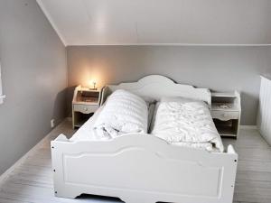 a white bed in a room with two night stands at 10 person holiday home in MIDSUND in Midsund