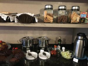 a kitchen counter with some food on a shelf at Pousada Natália in Torres