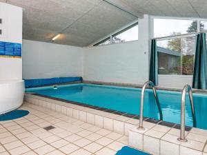 a large swimming pool in a room with a window at 8 person holiday home in Knebel in Knebel