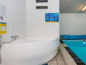 a white bath tub in a bathroom with a swimming pool at 8 person holiday home in Knebel in Knebel