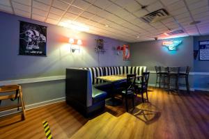 a restaurant with a bar with chairs and a table at Red Roof PLUS Newark Liberty Airport - Carteret in Carteret