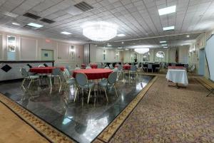 a banquet hall with red tables and chairs at Red Roof PLUS Newark Liberty Airport - Carteret in Carteret