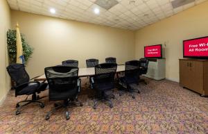 a conference room with a table and chairs and a screen at Red Roof PLUS Newark Liberty Airport - Carteret in Carteret