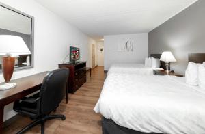 a hotel room with two beds and a desk at Red Roof PLUS Newark Liberty Airport - Carteret in Carteret