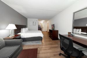 a hotel room with a bed and a desk at Red Roof PLUS Newark Liberty Airport - Carteret in Carteret