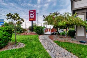 a sign for a pet food motel next to a building at Red Roof PLUS Newark Liberty Airport - Carteret in Carteret