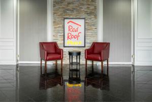 two red chairs and a cocacola sign in a room at Red Roof PLUS Newark Liberty Airport - Carteret in Carteret