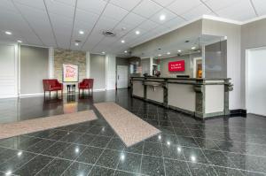 a lobby with a waiting room with red chairs at Red Roof Inn PLUS Newark Liberty Airport - Carteret in Carteret