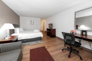 a hotel room with a bed and a desk at Red Roof Inn PLUS Newark Liberty Airport - Carteret in Carteret +37 photos