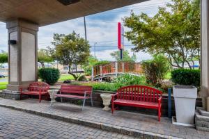 three red benches sitting outside of a building at Red Roof PLUS Newark Liberty Airport - Carteret in Carteret
