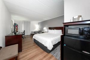 a hotel room with a bed and a television at Red Roof PLUS Newark Liberty Airport - Carteret in Carteret