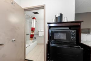 a kitchen with a microwave in a room at Red Roof PLUS Newark Liberty Airport - Carteret in Carteret