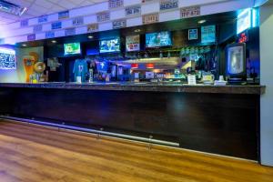 a bar with several televisions on a wall at Red Roof PLUS Newark Liberty Airport - Carteret in Carteret