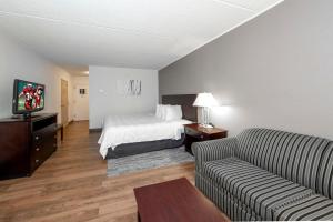 a hotel room with a bed and a couch at Red Roof PLUS Newark Liberty Airport - Carteret in Carteret